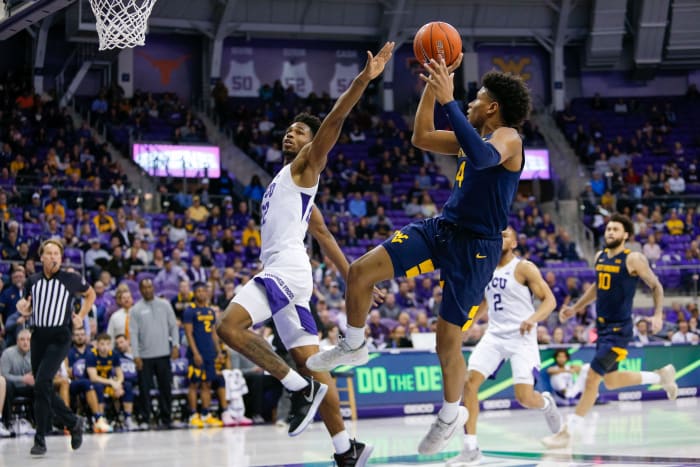 Feb 22, 2020; Fort Worth, Texas, USA; West Virginia Mountaineers guard Miles McBride (4) makes the fade away and is fouled by TCU Horned Frogs guard RJ Nembhard (22) during the second half at Ed and Rae Schollmaier Arena.